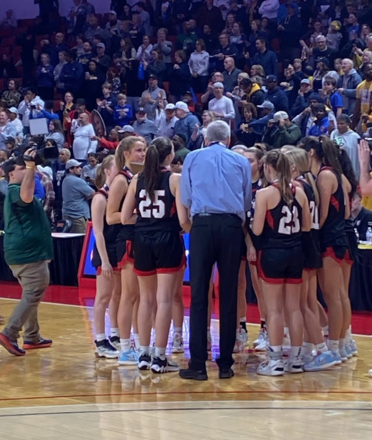 The girls varsity basketball team huddle before their game begins in Redbird Arena. 