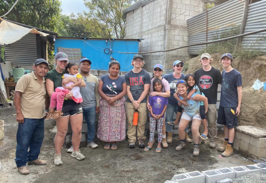 A+few+seniors+on+the+Guatemala+Spring+Break+service+trip+pose+with+a+family+for+whom+they+are+building+a+house.