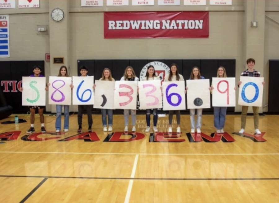 Students hold up the amount of money raised during the 2022 Christmas Drive.