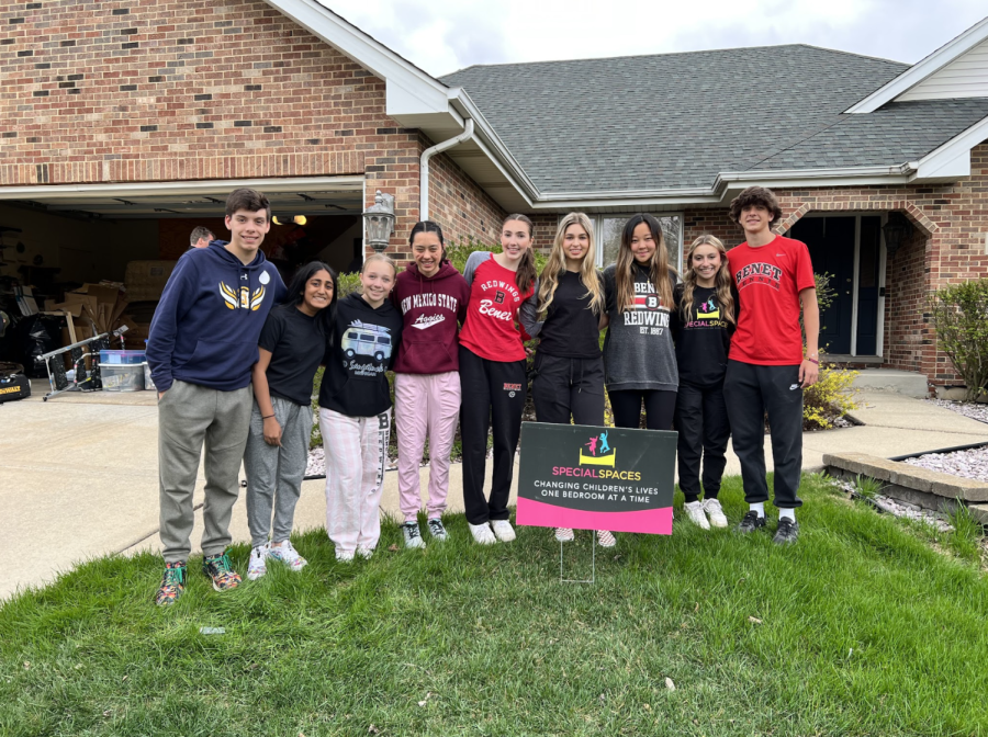 Benet Academy’s Special Spaces Club poses for a group picture outside the home they redecorated in April.