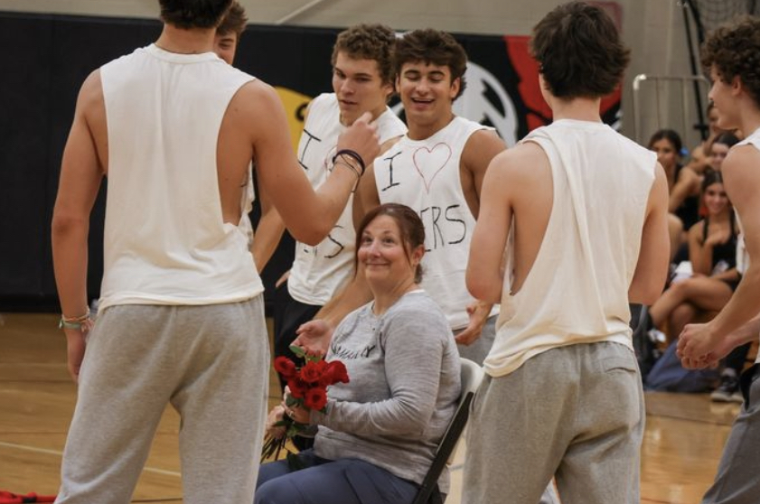 Seniors Gianluca DiCosola, Daniel Quinlan, and Hudson Schlie, among others, participate in a serenade of longtime Spanish teacher Mrs. Haas during the 2024 Homecoming Pep Rally.