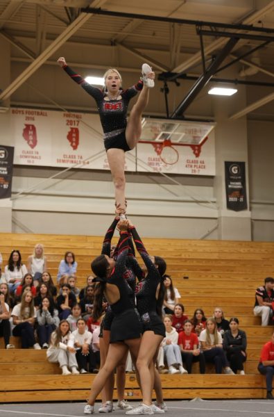 Autumn Johnson pull us of an exciting stunt at the top of the pyramid. This was part of the Varsity Cheer team’s performance. 